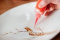 The process of painting dishes in Chinese style. Ornamenting the plate with paint. Royalty Free Stock Photo