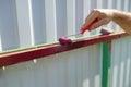 The process of painting the fence with hand ink Roller. Recolor surface. Repair background. Summer activity. Work outside.