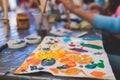 Process of painting, group class of young talented kids students with painting easels, and canvases during lesson of watercolour