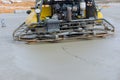 An of the process of polishing and leveling a cement screed mortar floor that is found on a construction site