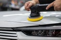 Process of polishing white car hood surface using orbital polishing machine. Royalty Free Stock Photo