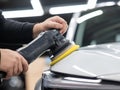 Process of polishing white car hood surface using orbital polishing machine. Royalty Free Stock Photo