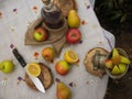 Process of preparing of apple juice and cider in the garden.Wooden table and apples, manual grinder for fruits, bottle on it. Royalty Free Stock Photo