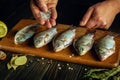 The process of preparing crucian fish on the kitchen table. Chef hands adding coarse salt before drying or cooking Rutilus Royalty Free Stock Photo