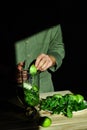 Process of preparing green detox smoothie with blender, young man cut apples