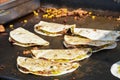 The process of preparing a quesadilla, traditional Mexican dish. Outdoor outside setting