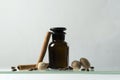 Cinnamon, nutmeg as ingredients for making oils and perfume. Brown glass bottle and spices against vintage brick wall