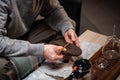 The process of preparing for the tea ceremony is a major one. Men`s hands break the tea for brewing in a ceramic teapot Royalty Free Stock Photo