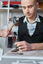 punching holes in the belt with the help of a puncher in the hands of a craftsman, a close-up of the hand-made