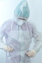 The process of putting on a medical protective anti-plague suit close-up. Young practitioner woman wearing protective