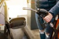 Process of refueling a car fill with petrol fuel at the gas station, pump filling fuel nozzle in fuel tank of car, high Royalty Free Stock Photo