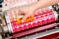 Process of removing possible dust debris on polymer plate in magenta print tower station with sticky roll on flexographic press.