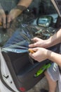 Close up of worker pulling off sun protection tinted foil from side car window Royalty Free Stock Photo