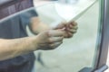 Close up of worker pulling off sun protection tinted foil from side car window Royalty Free Stock Photo