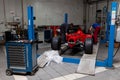 The process of repairing and restoring a red Ferrari Formula 1 car at a pitstop in the service station or a repair workshop on a