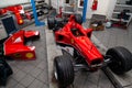 The process of repairing and restoring a red Ferrari Formula 1 car at a pitstop in the service station or a repair workshop on a