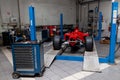 The process of repairing and restoring a red Ferrari Formula 1 car at a pitstop in the service station or a repair workshop on a