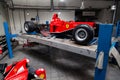 The process of repairing and restoring a red Ferrari Formula 1 car at a pitstop in the service station or a repair workshop on a