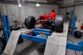 The process of repairing and restoring a red Ferrari Formula 1 car at a pitstop in the service station or a repair workshop on a Royalty Free Stock Photo