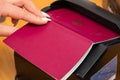 The process of scanning a German biometric passport to register the fact of crossing the state border. Female hand puts a passport