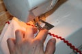 The process of sewing a red ribbon to a white fabric Royalty Free Stock Photo