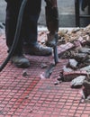 Process of sidewalk road repairing with jackhammer, builder worker with pneumatic hammer and drill equipment breaking asphalt Royalty Free Stock Photo