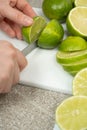 The process of slicing fresh lime fruit with a kitchen knife. Royalty Free Stock Photo