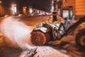 Process of snow removal on the city streets and roads with municipal vehicle, bulldozer, snowblower plow truck, snowplow, snow