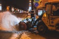 Process of snow removal on the city streets and roads with municipal vehicle, bulldozer, snowblower plow truck, snowplow, snow