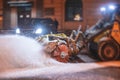 Process of snow removal on the city streets and roads with municipal vehicle, bulldozer, snowblower plow truck, snowplow, snow