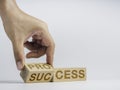 Process for success concept. Hand turning wooden cube block to change the words.