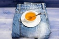 Process tea brewing in ceramic mug. Herbal green or black whole leaf. Mug filled boiling water and tea bag on blue jeans Royalty Free Stock Photo