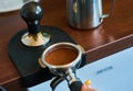 The process of temper coffee in holder, making espresso on coffee machine.