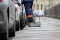 Process of urban street cleaning sweeping. Worker with broom and dust pan Royalty Free Stock Photo