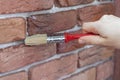 Process of varnishing grout between gypsum decorative bricks. Covering a brick wall with waterproofing coating.