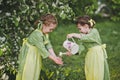 Children playing with a small watering can in the garden 8364.