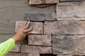 The process of worker laying decorative bricks stone on the wall. Royalty Free Stock Photo