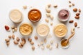 Processing nuts into vegan sauces and cheeses A variety of different flavors of peanut butter are on a white background. AI