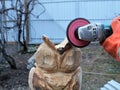 Grinding with sandpaper on a grinder of a wooden statue of a bird Royalty Free Stock Photo