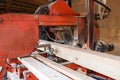 Processing wooden boards at a sawmill. The process of processing logs in the equipment of a sawmill saw a tree trunk on