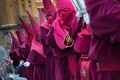 Procession of Catholic devotees in maroon capirotes during the Holy Week celebration in Murcia Spain