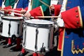 Procession of drummers with white drums, wearing a uniform