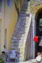 PROCIDA, ITALY, 1979 - A baby sleeps peacefully in his wheelchair at the foot of a staircase