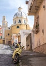 Procida, Italy. Church of Santa Maria delle Grazie Our Lady of Grace. Yellow Vespa scooter in the foreground.