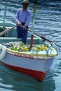 PROCIDA, ITALY, 1979 - A man sells lemons from his boat in the port of Procida