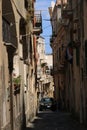 Narrow and old road on the Island of Procida. A luxury car passe