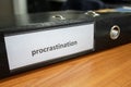 procrastination concept.procrastinating problem. written word at paper note stick. office paperwork stuff around it Royalty Free Stock Photo