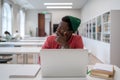 Pensive Black student man looking into distance while studying in library, disinterested in study