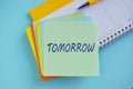 Procrastination, delay and urgency concept. Bad time management. Word TOMRROW on colorful sticky note Royalty Free Stock Photo