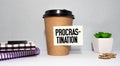 Procrastination inscription on a cup of coffee. concept of laziness